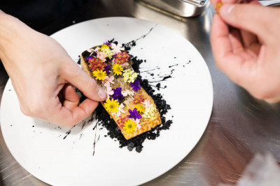 Koch richtet Gericht mit essbaren Blüten an – regionales Catering in Frankfurt von GOOSE Gourmet