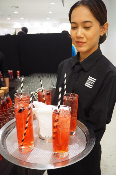 Servicekraft beim Verteilen der Cocktails