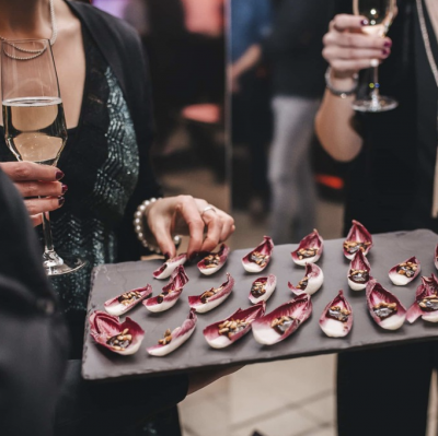 Platte mit Fingerfood wird verteilt eine Dame greift danach