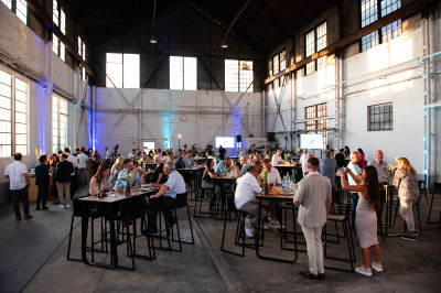 Große Halle im Industrielook mit vielen Gästen eines Events