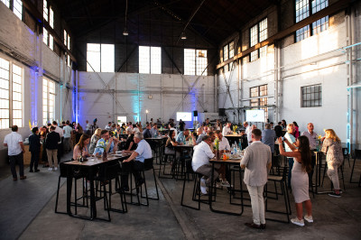 Große Halle im Industrielook mit vielen Gästen eines Events